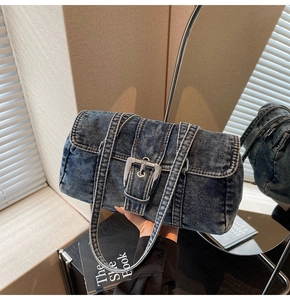 Détail du sac à épaule en denim délavé avec boucle argentée et texture vintage