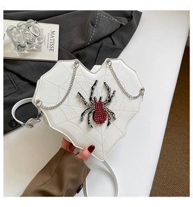 Detailansicht der herzförmigen Tasche aus weißem Leder mit Strassspinne und Spinnennetz