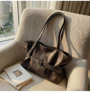 Détail du sac cabas en cuir marron foncé avec boucles argentées vintage et sangles