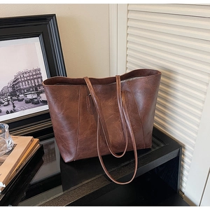 Close-up of vintage brown tote bag texture and slim shoulder straps for daily commute