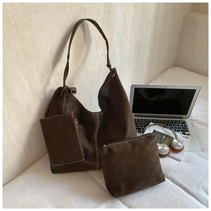 Detailed view of dark brown suede tote bag set with three pieces and white stitching details