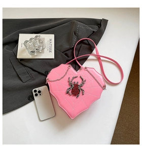 Detailansicht der herzförmigen rosa Tasche mit weißem Spinnennetz und Juwelspinne