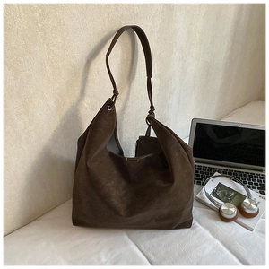 Detail view of large dark brown suede tote bag with laptop and office accessories