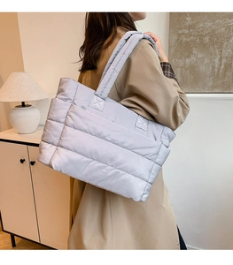 Detail view of light purple quilted puffer tote bag with wide padded shoulder strap