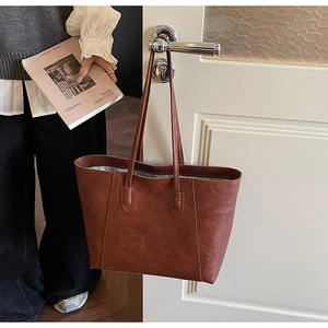 Detailed macro view of vintage brown leather tote bag with natural wrinkled texture
