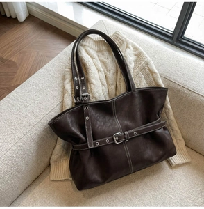 Détails du cabas marron foncé avec surpiqûres blanches et boucles de ceinture décoratives
