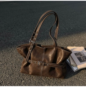Détail du sac cabas vintage en cuir marron foncé avec surpiqûres et boucle élégante