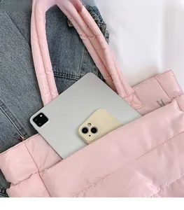 Pink quilted tote bag with spacious interior holding a tablet and phone