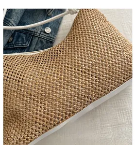 Gros plan sur le sac de plage en paille tisée avec poignées blanches et texture fine