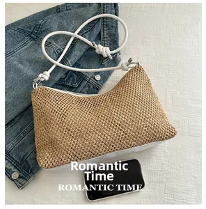 Détail d'un sac bandoulière en paille avec téléphone pour référence de taille et fermeture