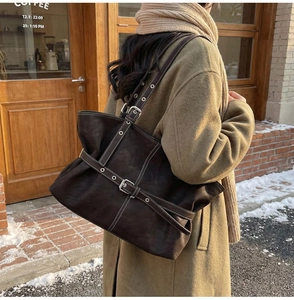Gros plan d'un cabas vintage en cuir marron foncé avec détails de sangles à boucles