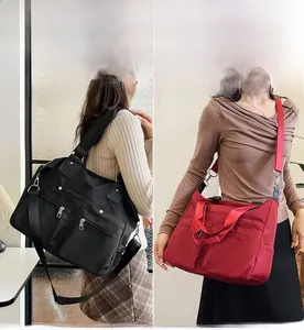 Détail de grands sacs fourre-tout en nylon imperméable disponibles en noir et rouge