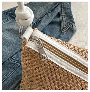 Détail de la fermeture éclair métallique et du liseré en similicuir blanc d'un sac en paille