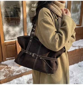 Détail du sac cabas marron foncé avec surpiqûres blanches et boucles de ceinture argentées