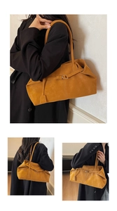 Detalle de un bolso tote vintage amarillo mostaza con textura de cuero mate y asas