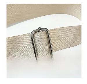 Détail macro d'une bandoulière en sergé haute densité avec boucle métallique réglable argent