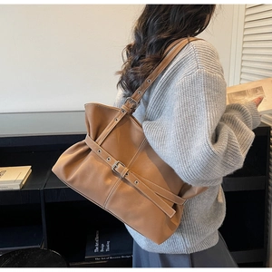 Détail d'un grand sac cabas plissé marron foncé avec boucles métalliques rétro chic
