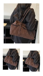 Detalle de un bolso tote grande de ante marrón con correas largas y cordón decorativo