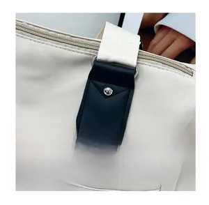 Détail de la bandoulière en nylon renforcé avec patch en cuir noir et rivets