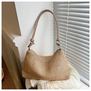 Détail d'un sac de plage tressé avec des bretelles en cuir et une fermeture éclair