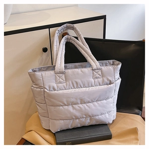 Detail of light grey quilted tote bag showing smooth nylon texture and horizontal stitching