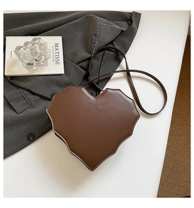 Detail der dunkelbraunen herzförmigen Umhängetasche mit pixeligen Kanten und weißen Nähten