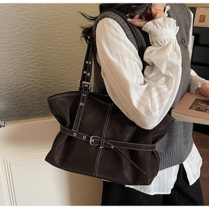 Détail du sac cabas vintage avec surpiqûres blanches contrastées et boucles métalliques réglables
