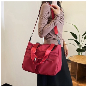 Détail d'un sac cabas en nylon rouge imperméable avec poches zippées fonctionnelles à l'avant