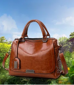 Détail du sac à main vintage marron avec double poignée et bandoulière réglable