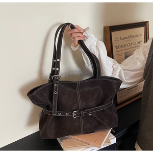 Détail d'un sac cabas rétro marron avec surpiqûres blanches et boucle de ceinture réglable