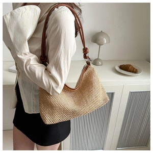 Détail du sac bandoulière en paille avec bandoulière en cuir noué et fermeture éclair