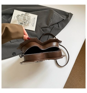 Detail der herzförmigen Tasche mit Reißverschluss, Innenraum und silberner Kette