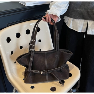 Détail du sac cabas marron foncé avec coutures blanches contrastées et boucle décorative