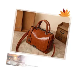 Détails d'un sac à main vintage en cuir caramel avec rivets métalliques et poignée