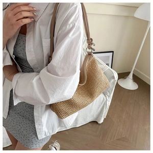 Détail du sac en paille tissé à la main avec lanières en cuir et nœuds pour l'été