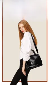 Détail d'un sac à main vintage en cuir noir mat avec rivets argentés et bandoulière