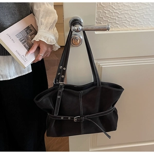 Détail d'un cabas en cuir noir avec surpiqûres blanches contrastées et ceinture décorative