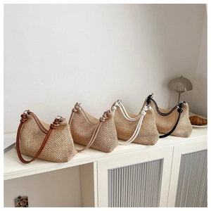 Détail de sacs à bandoulière en paille tressée en quatre couleurs avec nœuds décoratifs