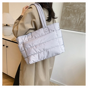 Close-up of a lavender quilted tote bag with a soft puffy texture worn by a model