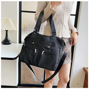 Détail du sac cabas en nylon noir avec doubles poches zippées et bandoulière réglable