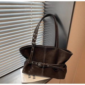 Détail du sac fourre-tout marron foncé avec surpiq coutures blanches et boucles de sangle