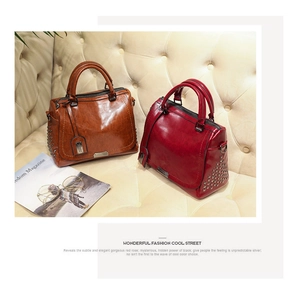 Sacs à main rétro en cuir gras avec rivets en marron et bordeaux sur un canapé chic