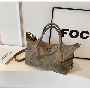 Detail of vintage matte leather tote showing side pocket and dual-zipper closure