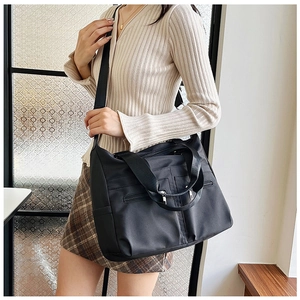 Détail du sac en nylon noir étanche montrant plusieurs poches zippées pratiques