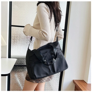 Détail du sac à main en nylon noir imperméable avec poches zippées et bandoulière large
