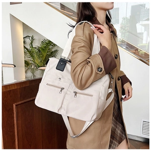Détail du sac fourre-tout beige en nylon avec deux poches zippées et bandoulière large