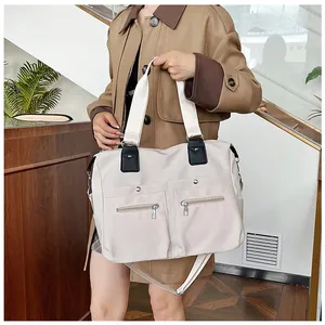 Détail du grand sac cabas en nylon imperméable avec poches avant et bandoulière réglable