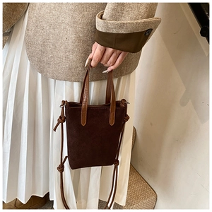 Vertical view of a vintage leopard-style brown suede crossbody bag with long knot strap detail