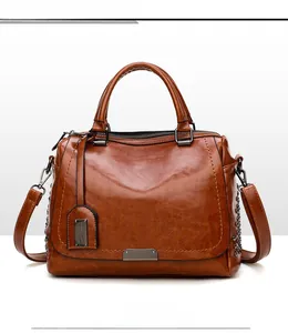 Détail du sac en cuir marron avec rivets décoratifs et finitions métalliques sombres