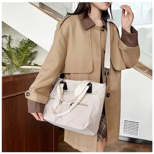 Détail du sac cabas en nylon beige avec poches zippées et bandoulière réglable